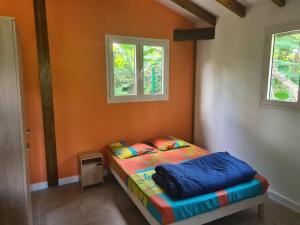Cama en habitación con 2 ventanas en Bung-hello Village,Petit Bungalow confortable avec jacuzzi en Trois-Rivières