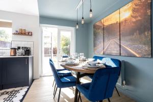 a dining room with a table and blue chairs at Stylish Railway Themed House - Central Warrington in Warrington