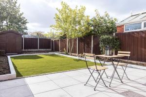 a small garden with a table and chairs on a patio at Stylish Railway Themed House - Central Warrington in Warrington