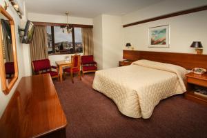 a hotel room with a bed and a table and chairs at Hotel Diplomat in Cochabamba