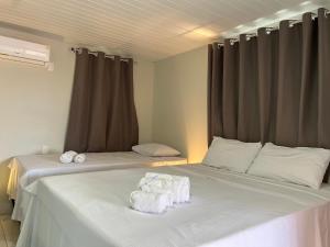 sypialnia z 2 łóżkami i ręcznikami w obiekcie Pousada Solar Maia Costa w mieście Atins