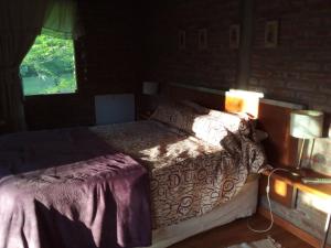 1 dormitorio con cama y ventana en CASA CAMPO en Villa General Belgrano