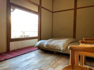 A bed or beds in a room at 平屋古民家と薪サウナ サササウナ