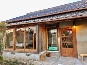 a house with glass windows and a wooden door at 淡路島 サササウナ in Awaji