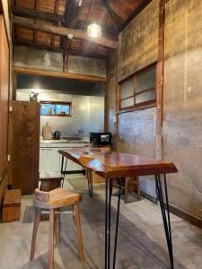 una cocina con mesa de madera y taburete. en 淡路島 サササウナ en Awaji