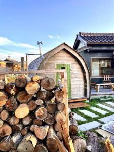 a pile of logs in front of a cabin at 淡路島 サササウナ in Awaji