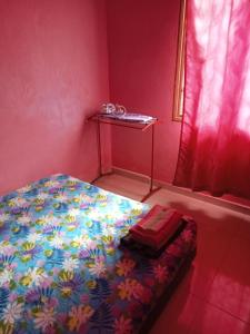a small bedroom with a bed with a colorful blanket at HOMESTAY CAHAYA PUTERI in Tangga Batu