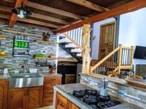 une cuisine avec cuisinière et un escalier en bois dans l'établissement El Encanto Mountain Cabin, à Salento