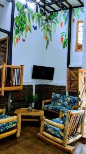 a living room with chairs and a flat screen tv at El Encanto Mountain Cabin in Salento