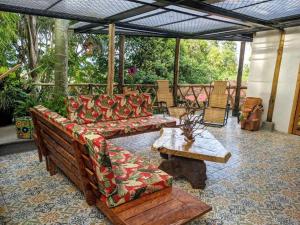 un patio con sofás, mesa y sillas en El Encanto Mountain Cabin, en Salento