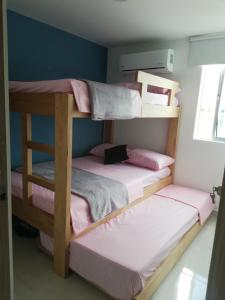 2 literas en una habitación pequeña con sábanas rosas en Apartamento en caribe campestre, en Coveñas