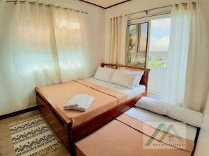 Dormitorio pequeño con cama y ventana en Mireya's 1BR condo at Zone Vill - Burnham Park, en Baguio