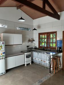 a kitchen with white appliances and a table in it at Casa Colmeia in Lençóis