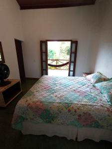una camera da letto con un letto con un piumone colorato di Casa Colmeia a Lençóis