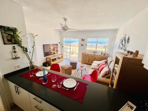 kuchnia i salon ze stołem i czerwonymi krzesłami w obiekcie The Heights - Los Cristianos w mieście Los Cristianos