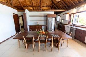 cocina grande con mesa de madera y sillas en Villa Vanua - Private Luxury Villa, en Rakiraki