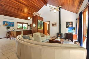 ein Wohnzimmer mit einem Sofa und einem Tisch in der Unterkunft Semaphore Beach House in Hawks Nest