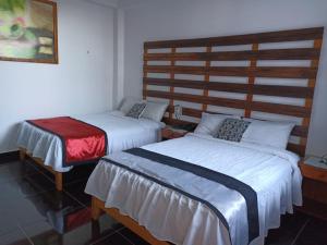 Habitación pequeña con 2 camas en Hotel Rulman, en Puerto Maldonado
