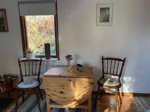 Habitación con 2 sillas, mesa de madera y ventana en Holiday home Hillerstorp, en Hillerstorp
