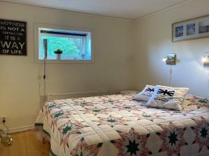 ein Schlafzimmer mit einem Bett mit einer Decke und einem Fenster in der Unterkunft Holiday home HÅLTA in Kode