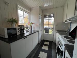 een keuken met witte kasten en een zwart aanrecht bij Holiday home Malmbäck II in Malmbäck