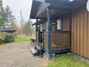 een gebouw met een veranda met een bank en bloemen bij Holiday home Malmbäck II in Malmbäck