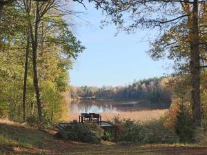 a bench sitting in front of a lake at 4 person holiday home in SKÅNES-FAGERHULT-By Traum in Slättsjö
