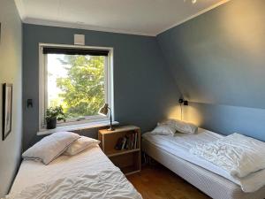 two beds in a room with a window at Holiday home TORSLANDA III in Torslanda