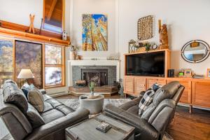a living room with two couches and a tv at Pines 2041 in Keystone