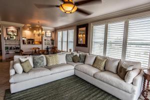 a large white couch in a living room with windows at Caddyshack Condo in Big Blackjack Landing