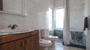 ein Badezimmer mit Toilette und Waschbecken und einem Fenster in der Unterkunft Casa Cor de Rosa in Madalena + 36 Fotos