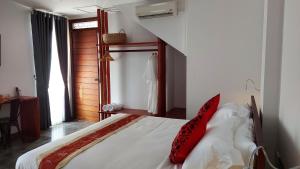 een slaapkamer met een bed met een rood kussen erop bij Sok Hotel And Coffee Siem Reap in Siem Reap