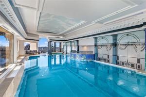 a swimming pool in a building with a view of the city at Comfy One Bedroom Apartment In Heart of The Rocks in Sydney