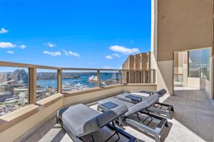 Un balcón con sillas y vistas al océano. en Comfy One Bedroom Apartment In Heart of The Rocks, en Sídney