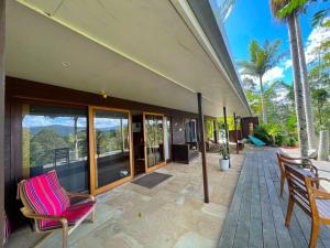 una casa con patio arredato con sedie e palme di Golden Retreat Ultimate 5 Bed - Villa & Guesthouse a Uki