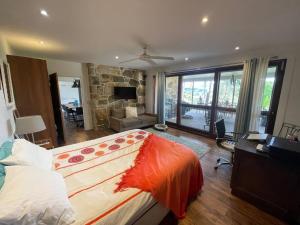 una camera con un grande letto e un soggiorno di Golden Retreat Ultimate 5 Bed - Villa & Guesthouse a Uki