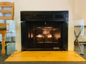 a fireplace with its door open in a living room at Whispering Pines Lodge in Kernville