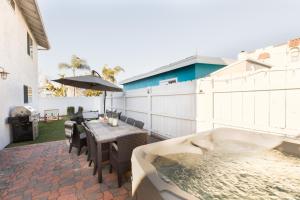 a patio with a tub and a table and a bathtub at Indigo By AvantStay Sleek Charming Home 2 Blks from Bay w Hot Tub in San Diego