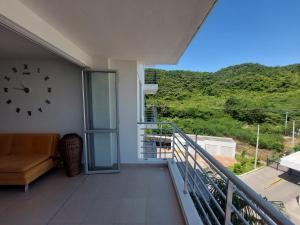 een balkon met een klok aan de muur en een bank bij Apartamento Aqualina Orange Piso 5 Vista a Montañas 2 Habitaciones in Girardot