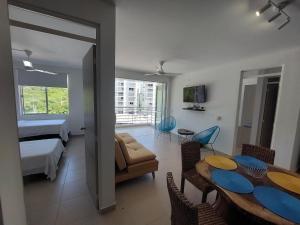 ein Wohnzimmer mit einem Esstisch und ein Schlafzimmer in der Unterkunft Apartamento Aqualina Orange Piso 5 Vista a Montañas 2 Habitaciones in Girardot