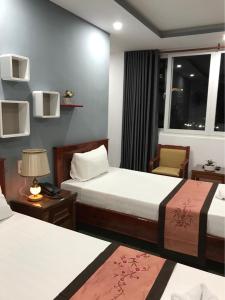 een hotelkamer met 2 bedden en een raam bij Sunny A Hotel in Hue