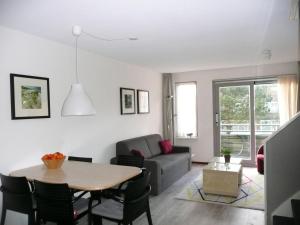 ein Wohnzimmer mit einem Tisch und einem Sofa in der Unterkunft Kaapshoff 32 in Hollum