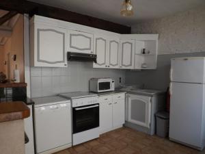 uma cozinha com armários brancos e um frigorífico branco em Gîte Billy, 2 pièces, 4 personnes - FR-1-489-1 em Billy