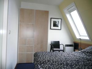 - une chambre avec un lit, une fenêtre et une chaise dans l'établissement Kaapshoff 32, à Hollum