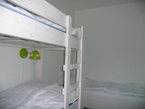 een wit stapelbed in een kamer met een stapelbed bij Kaapshoff 32 in Hollum +9 foto's