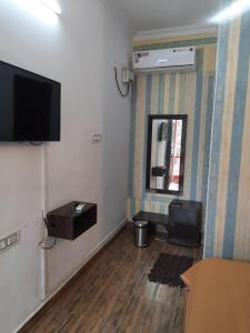 a room with a flat screen tv and a mirror at Cherry blossom guest house in Arpora