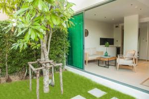 a garden with a tree in the middle of a house at Fisherman House Residence Pranburi in Sam Roi Yot