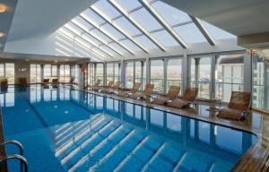 a large swimming pool with chairs in a building at WOW Istanbul Hotel in Istanbul