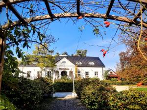 a white house with a black roof at Dwór na Wichrowym Wzgórzu in Przybysławice