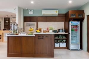 a kitchen with a refrigerator freezer next to a counter at Huen Hug Chiang Mai in Chiang Mai